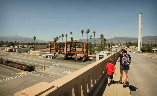 A women and child walk along the Mt. Vernon Bridge that goes over the BNSF rail yard in San Bernardino in this August 2013 photo. (File photo by Stan Lim / Southern California News Group) 