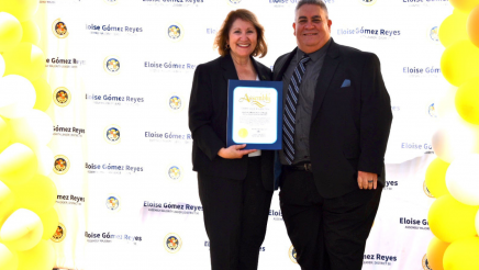 Nonprofit of distinction honoree stands with Majority Leader Reyes