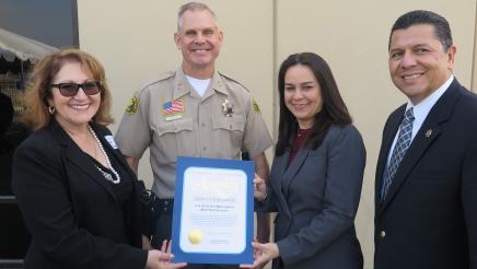 Assemblymember Reyes taking a picture with guest and their certificate