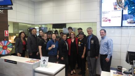 Assemblymember Reyes taking a photo with management and employees 