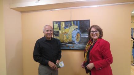 Assemblymember Reyes taking a picture with host and his art 