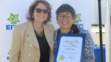 Assemblymember Reyes taking a photo with guest and her certficate 